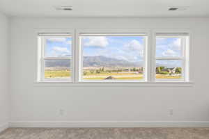 Carpeted spare room with baseboards and a mountain view