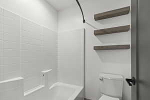 Bathroom featuring shower / bath combination and toilet