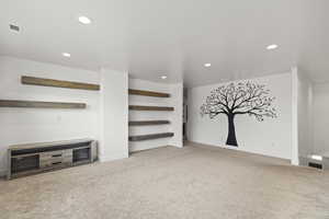 Unfurnished living room featuring light colored carpet and recessed lighting
