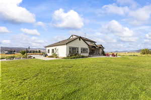 Rear view of house with a mountain view, stucco siding, and a yard