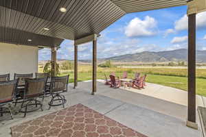 View of patio / terrace featuring a mountain view, outdoor dining space, and a view of rural / pastoral area