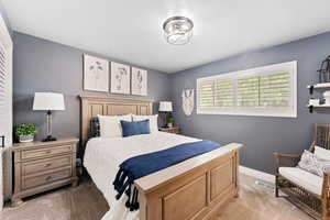 Bedroom with light carpet and baseboards