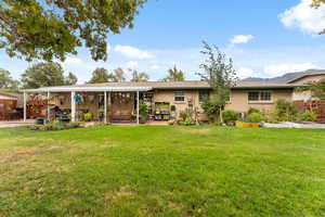 Rear view of property with brick siding, a patio area, and a vegetable garden