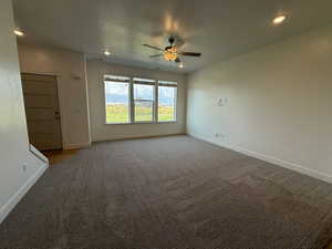 Unfurnished living room with light colored carpet, recessed lighting, ceiling fan, and a textured ceiling