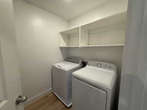 Washroom with light wood-type flooring and separate washer and dryer