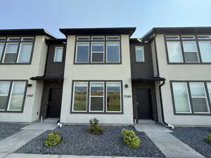 View of front facade featuring stucco siding and brick siding