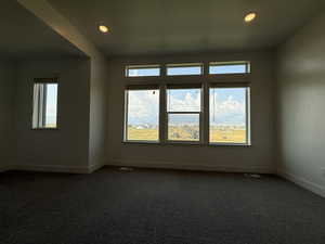 Empty room featuring dark carpet and recessed lighting