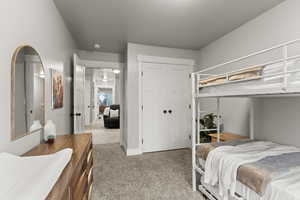 Bedroom with light colored carpet and a closet