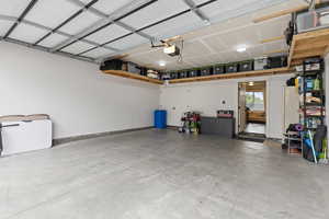 Garage with freestanding refrigerator and a garage door opener