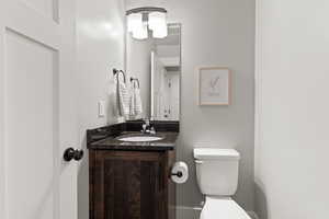 Half bathroom featuring vanity and toilet