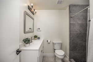 Full bathroom featuring a stall shower, vanity, and light tile patterned flooring