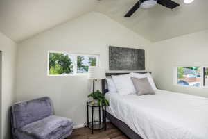 Bedroom with wood finished floors, a ceiling fan, and lofted ceiling