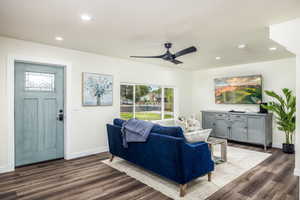 Living room with recessed lighting, healthy amount of natural light, dark wood-style floors, and ceiling fan