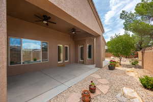 Fenced backyard with ceiling fan and a patio area