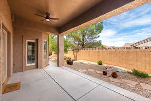 Fenced backyard with a patio and ceiling fan