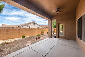 Fenced backyard featuring a patio and a ceiling fan