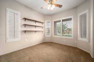 Unfurnished room with carpet floors and a ceiling fan