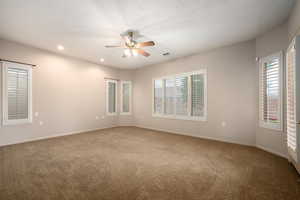 Carpeted spare room with healthy amount of natural light, recessed lighting, and ceiling fan