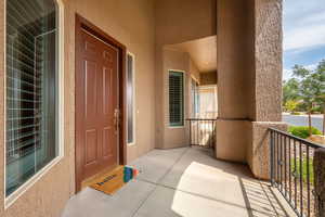 Doorway to property featuring stucco siding and a porch