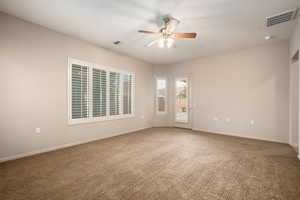 Carpeted empty room with a ceiling fan and baseboards