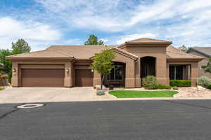 View of front of house featuring concrete driveway, stucco siding, a tiled roof, and an attached garage