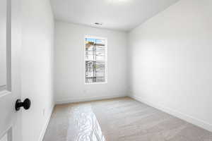 Empty room with light colored carpet and baseboards