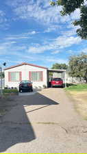 View of front facade featuring asphalt driveway and a carport