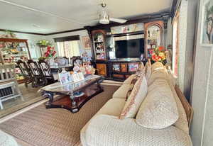 Living area featuring ceiling fan and ornamental molding