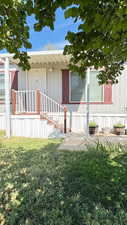 Doorway to property featuring a lawn and covered porch