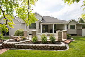 Rear view of house with a patio area, roof with shingles, a lawn, and board and batten siding