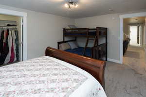 Bedroom featuring light carpet and a closet