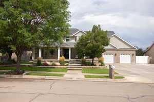 Obstructed view of property with a porch, driveway, brick siding, and a garage