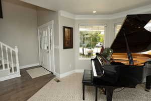 Entryway featuring stairway, ornamental molding, and wood finished floors