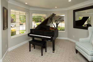Sitting room featuring light colored carpet, crown molding, and recessed lighting