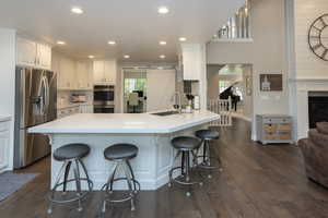 Kitchen with white cabinetry, healthy amount of natural light, appliances with stainless steel finishes, recessed lighting, and a breakfast bar