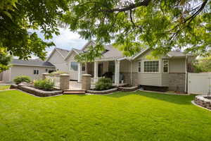 Rear view of property with a gate, brick siding, a shingled roof, and a patio area