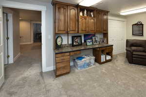 Home office with light colored carpet and baseboards