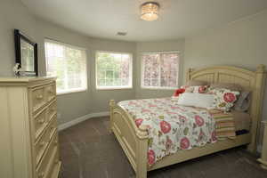 Bedroom featuring dark carpet and baseboards