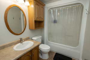 Full bath featuring shower / bath combo with shower curtain, vanity, and tile patterned flooring