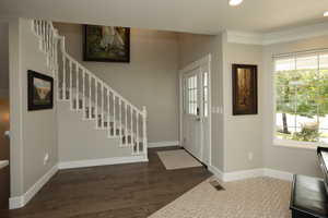 Entryway featuring recessed lighting, dark wood-style floors, crown molding, and stairway