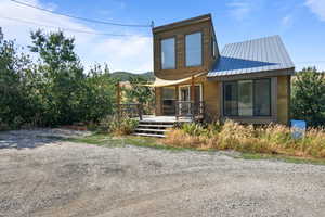Back of house featuring a metal roof and a deck