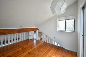 Bonus room with vaulted ceiling and hardwood / wood-style flooring