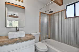 Bathroom featuring healthy amount of natural light, bathtub / shower combination, and vanity