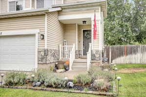 Entrance to property with stone siding and an attached garage
