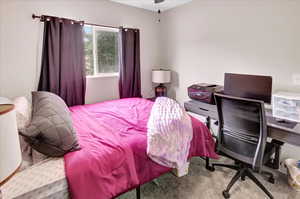 Carpeted bedroom featuring a desk