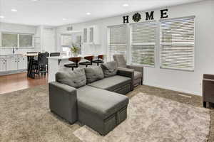 Living room with recessed lighting and light colored carpet