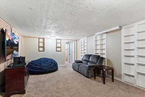 Living area with carpet flooring and a textured ceiling