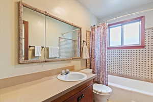 Full bath with shower / tub combo with curtain and vanity