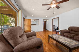 Living area featuring a textured ceiling, light wood-style floors, recessed lighting, and a ceiling fan