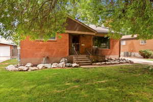 View of front of house featuring a front lawn and brick siding